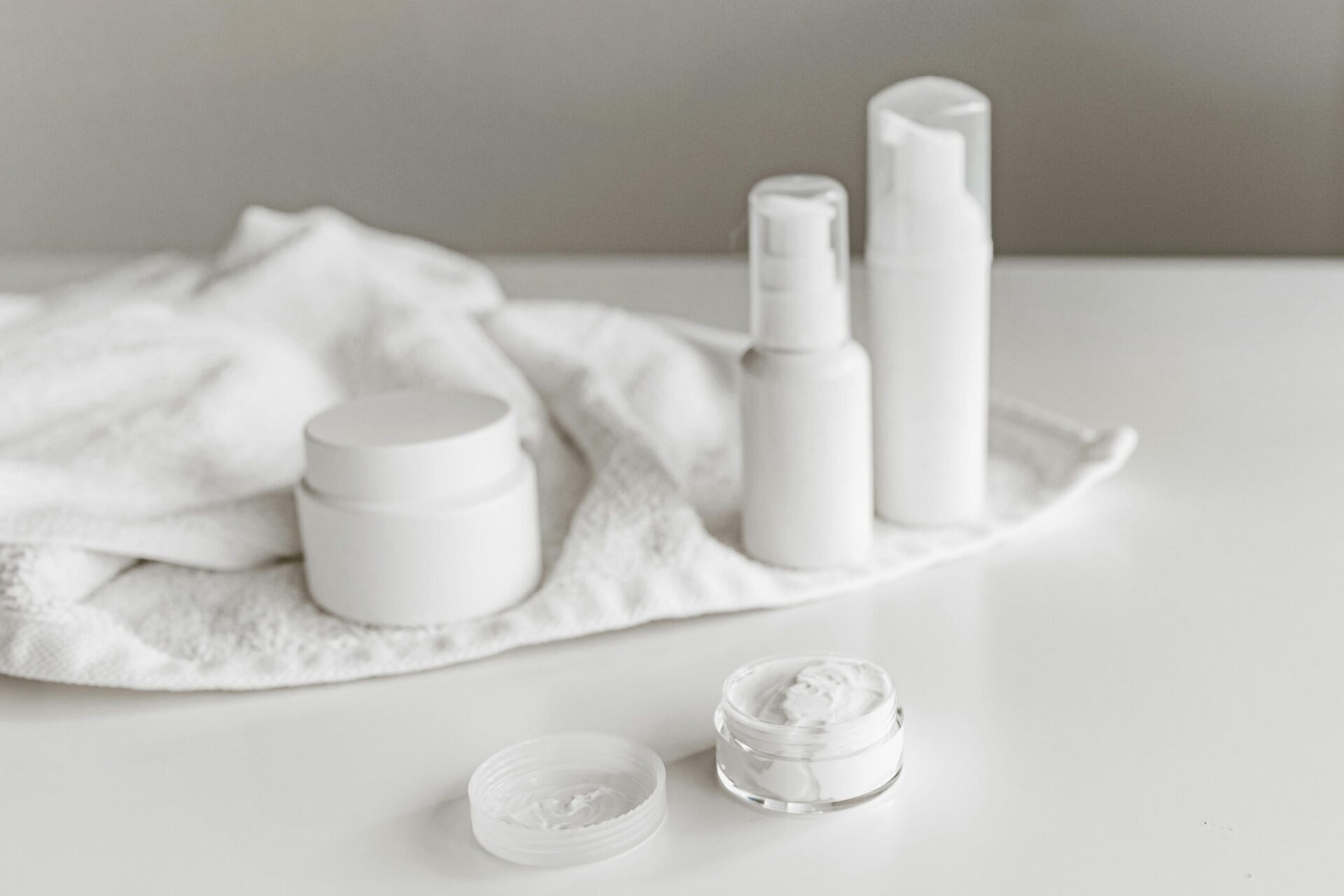 Elegant display of skincare products on a white surface, highlighting simplicity and purity.
